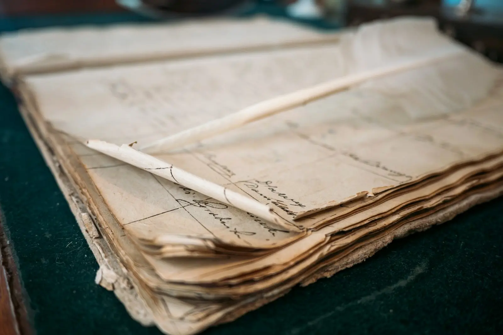 An aged manuscript ledger with brittle, browned and foxed pages and a cracked binding, the kind of paper deterioration that unstable temperature and humidity accelerate