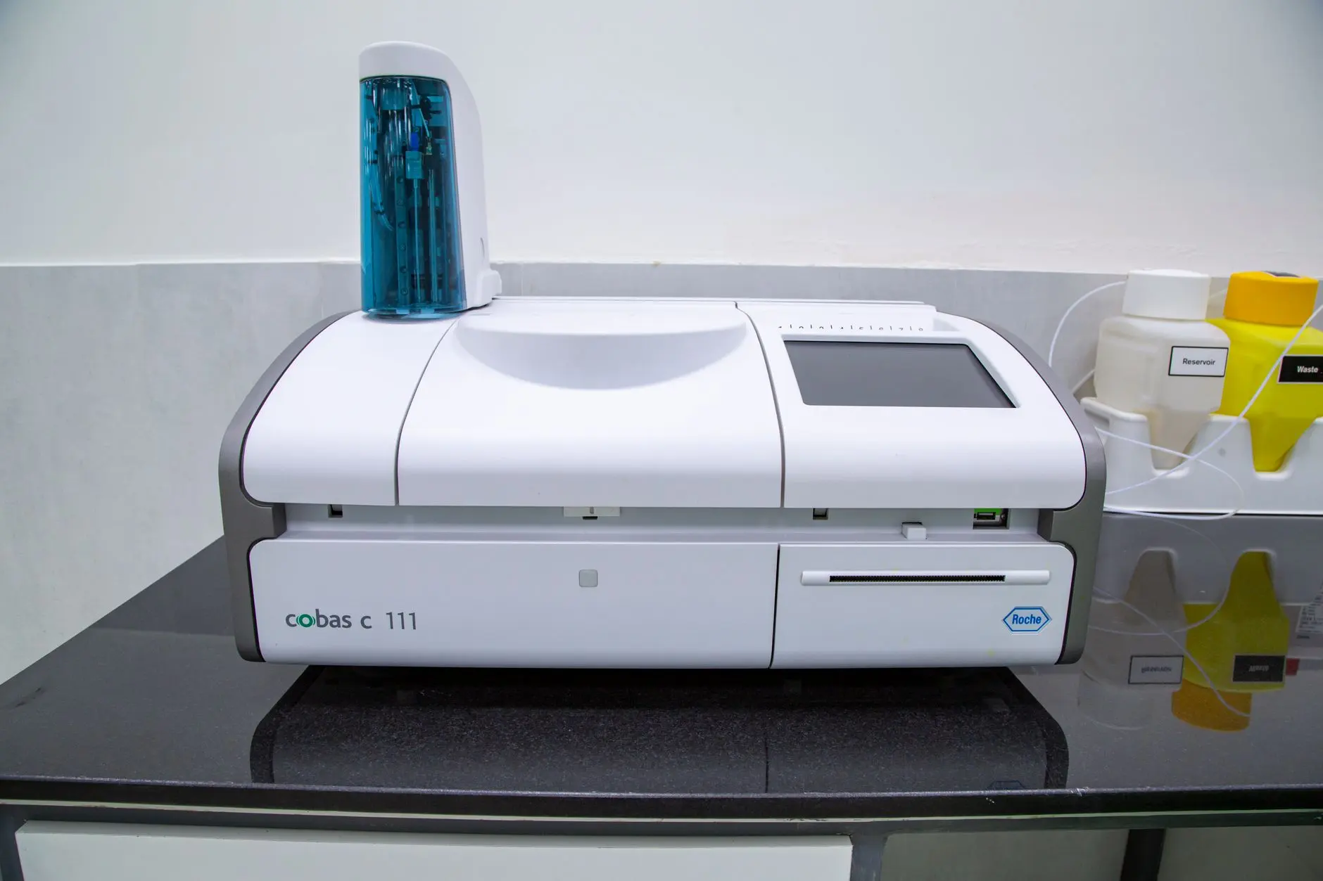 A clinical analyser on a diagnostic laboratory bench, the kind of continuously monitored life-science environment where a verifiable, timestamped data record supports both compliance and sustainability reporting