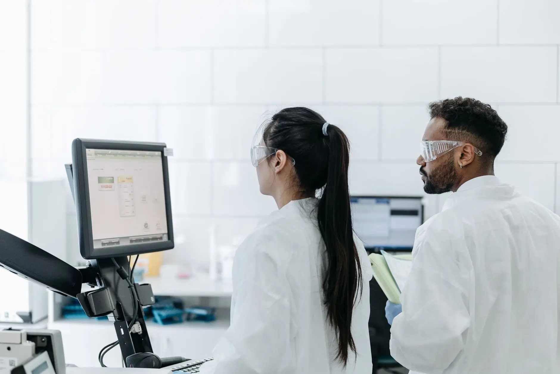 A laboratory scientist reviewing environmental monitoring data on a computer screen in a modern lab