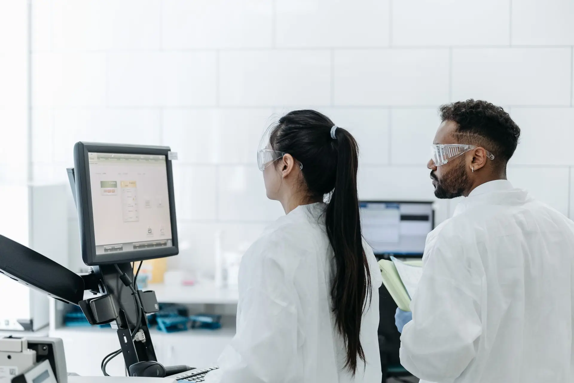 A laboratory scientist reviewing environmental monitoring data on a computer screen in a modern lab