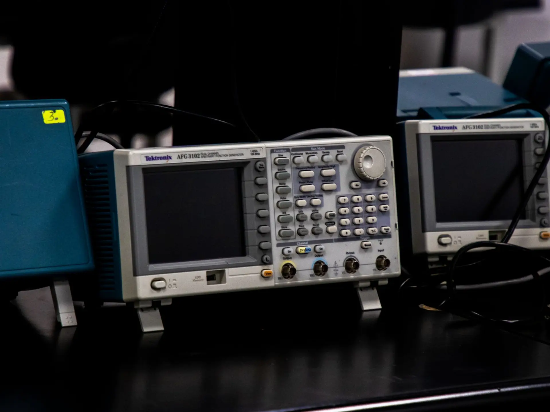 A darkened laboratory at night lit only by equipment displays, evoking an out-of-hours freezer alarm