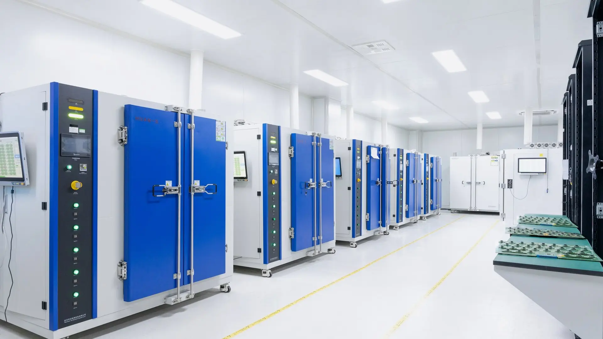 A row of temperature-controlled environmental chambers in a laboratory, each with its own monitoring panel