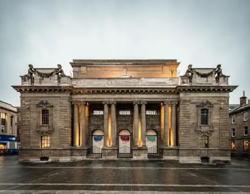A grand neoclassical heritage building at dusk, the kind of historic fabric Eltek environmental monitoring is trusted to protect