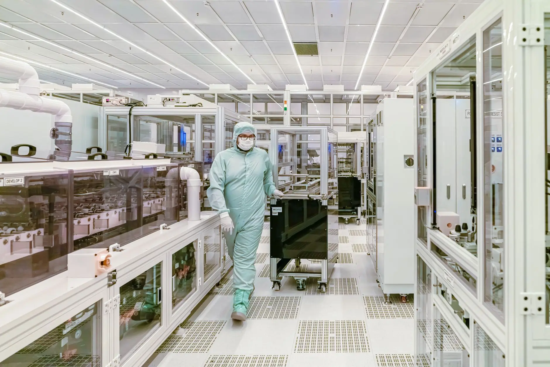 A gowned operator moving through a high-grade pharmaceutical cleanroom, the kind of regulated GMP manufacturing environment Eltek monitors continuously for temperature and humidity with audit-ready records