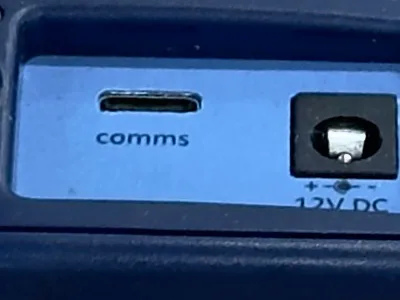 Close detail of the Eltek RP250 top panel showing the comms micro-USB port and the 12V DC power jack used to set up and power the wireless repeater