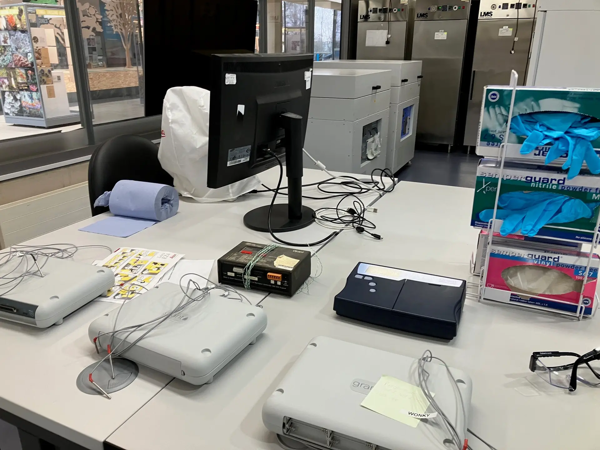 Grant Squirrel data loggers and thermistor probes on a university sports-science lab bench, with environmental chambers behind