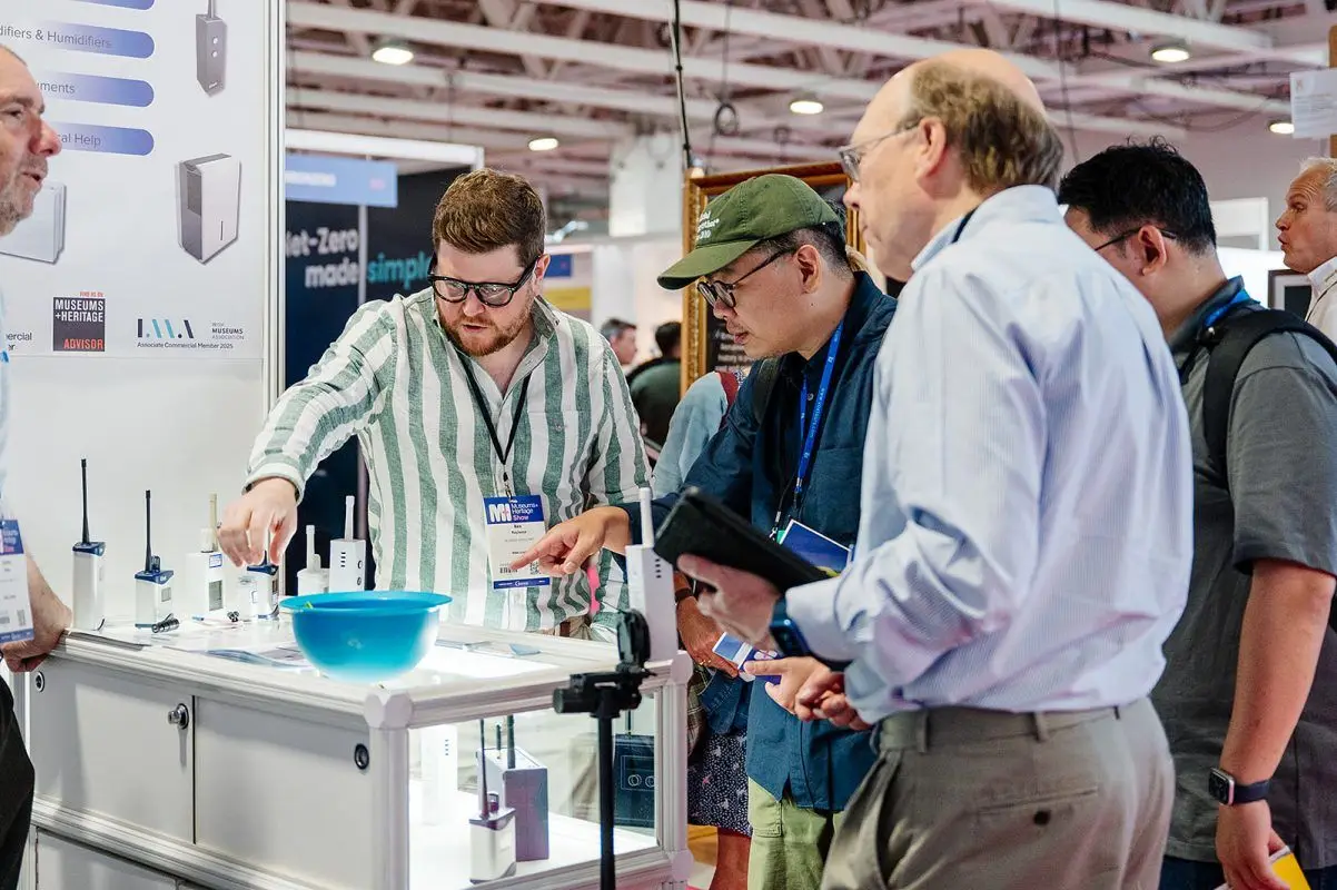 An Eltek team member showing wireless monitoring devices to visitors at an exhibition stand