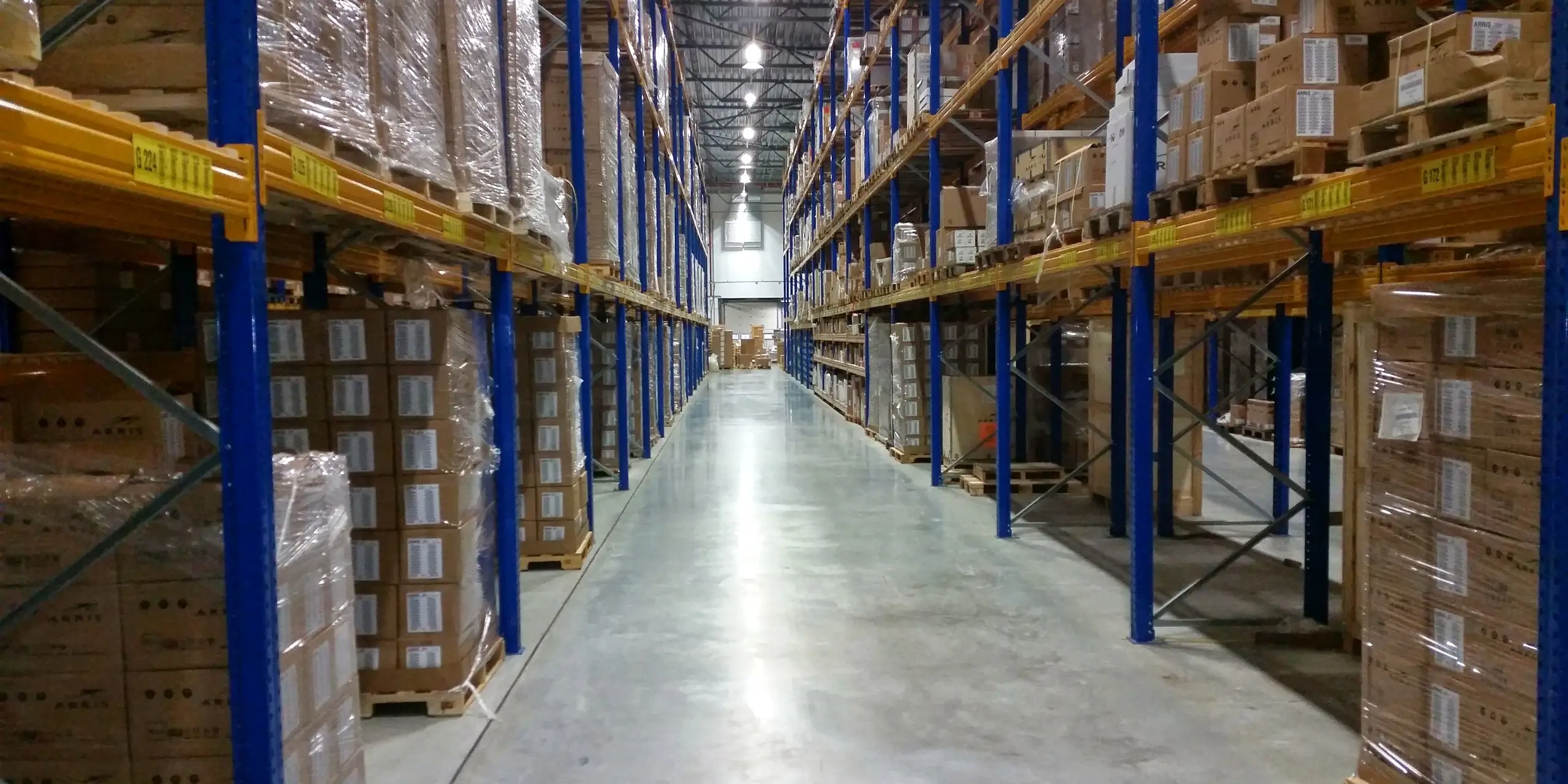 A long aisle of high racking in a temperature-controlled pharmaceutical warehouse, the subject of the temperature mapping complete guide